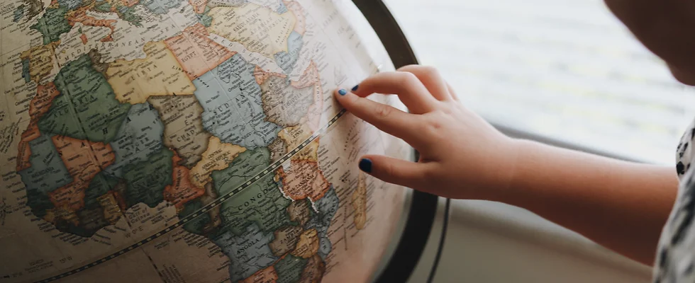 Geography Day Photo of a student pointing at a globe